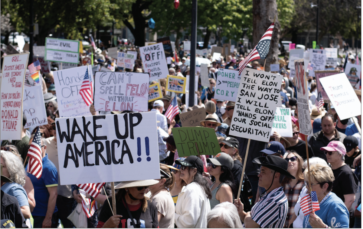 A crowd numbering thousands of &#8216;Hands Off !&#8217; protesters hold handmade signs expressing their frustration at the Trump administration while gathering in St. James Park.